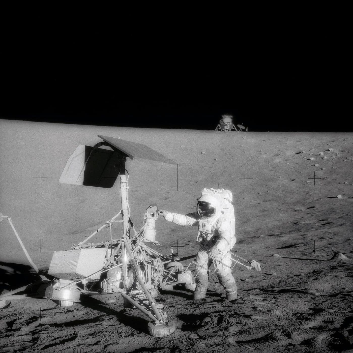 Astronaut u sondy Surveyor 3; na obzoru stojí lunární modul Intrepid — přistání jen ~160 m od sondy (NASA).