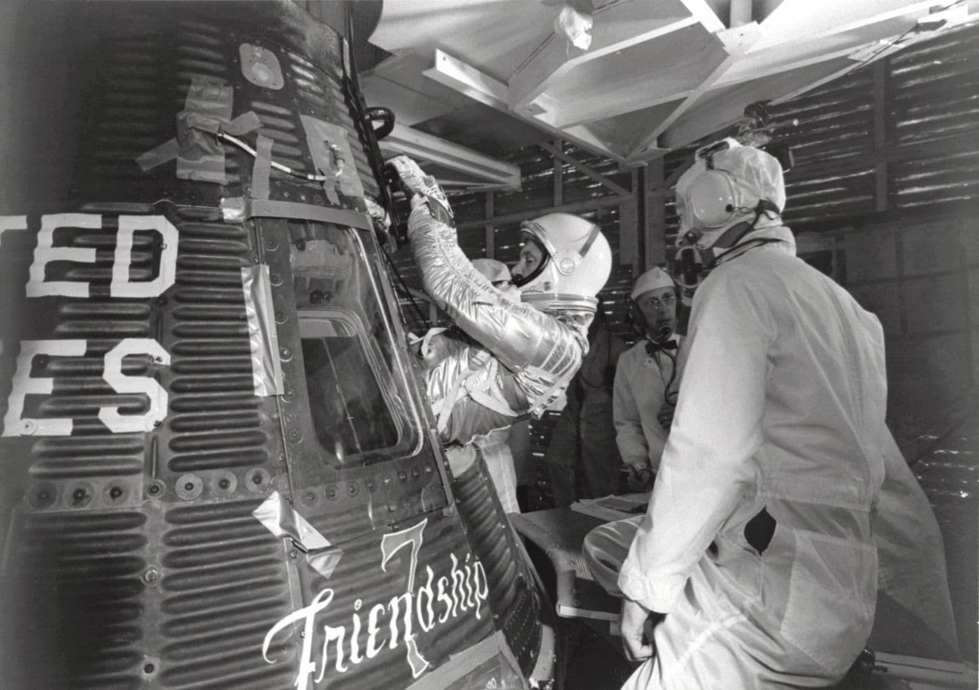 John Glenn nastupuje do kapsle Friendship 7, na trupu čitelný nápis „Friendship 7" (NASA).