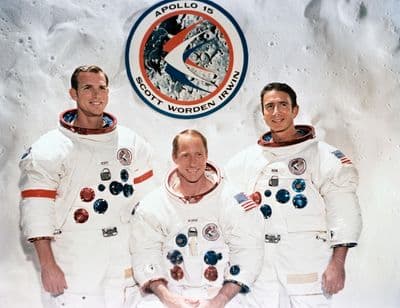 Posádka Apolla 15 (Scott, Worden, Irwin) na pozadí znaku mise (NASA).