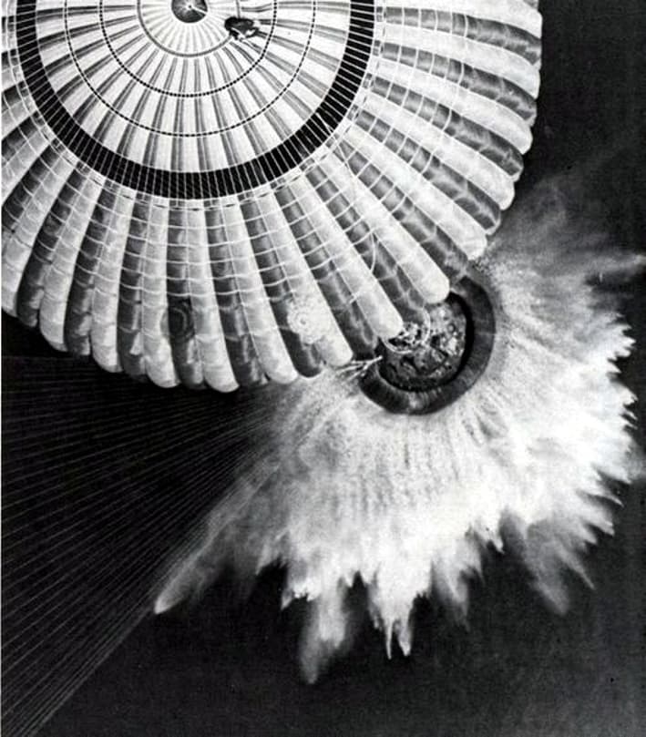 The Apollo 17 command module descends on three parachutes to splashdown in the Pacific Ocean, 19 December 1972.