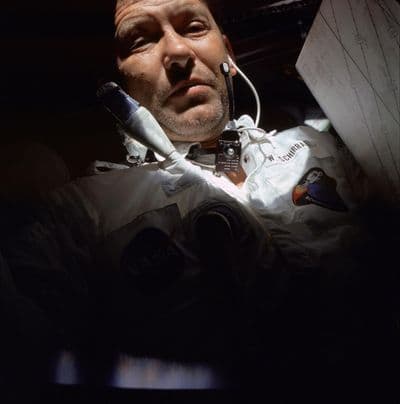 Walter Cunningham při plnění úkolů letu v kabině Apolla 7 — na skafandru čitelná jmenovka „Cunningham" (NASA).