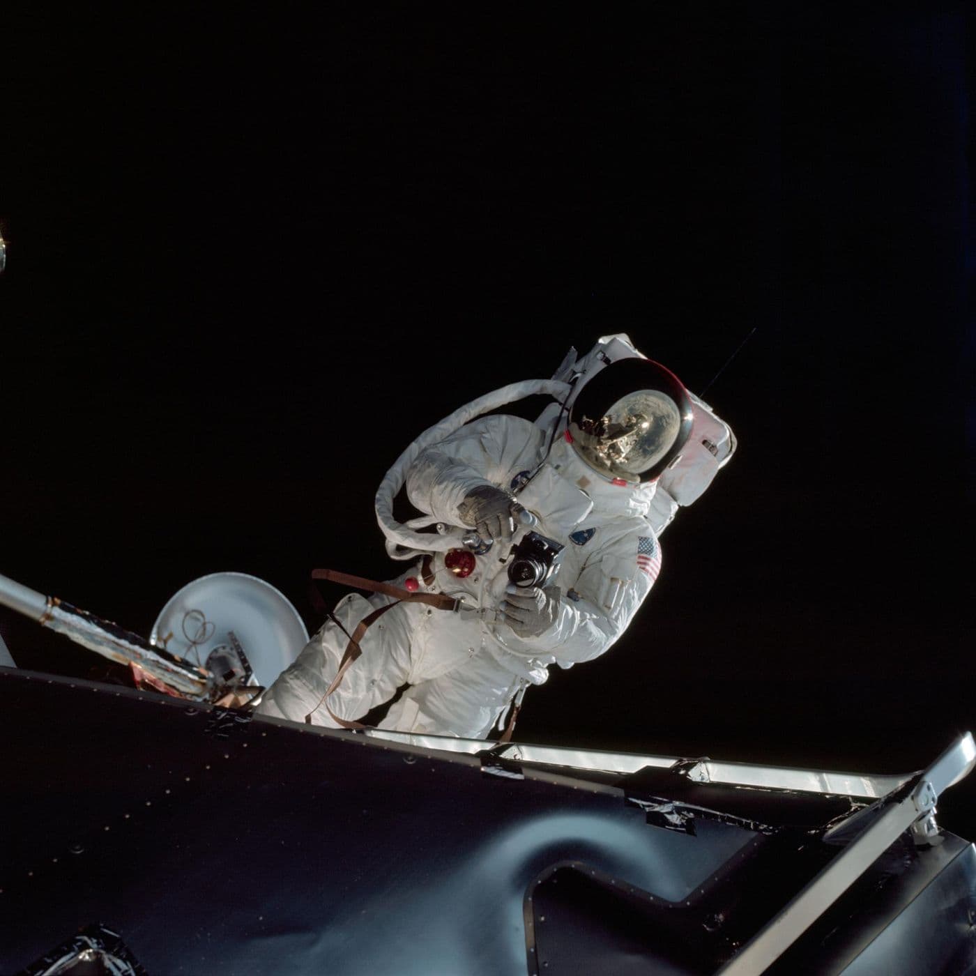 Astronaut Russell Schweickart při výstupu do vesmíru (EVA) u modulu Spider, v hledí odraz lunárního modulu (NASA).