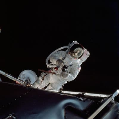 Astronaut Russell Schweickart při výstupu do vesmíru (EVA) u modulu Spider, v hledí odraz lunárního modulu (NASA).