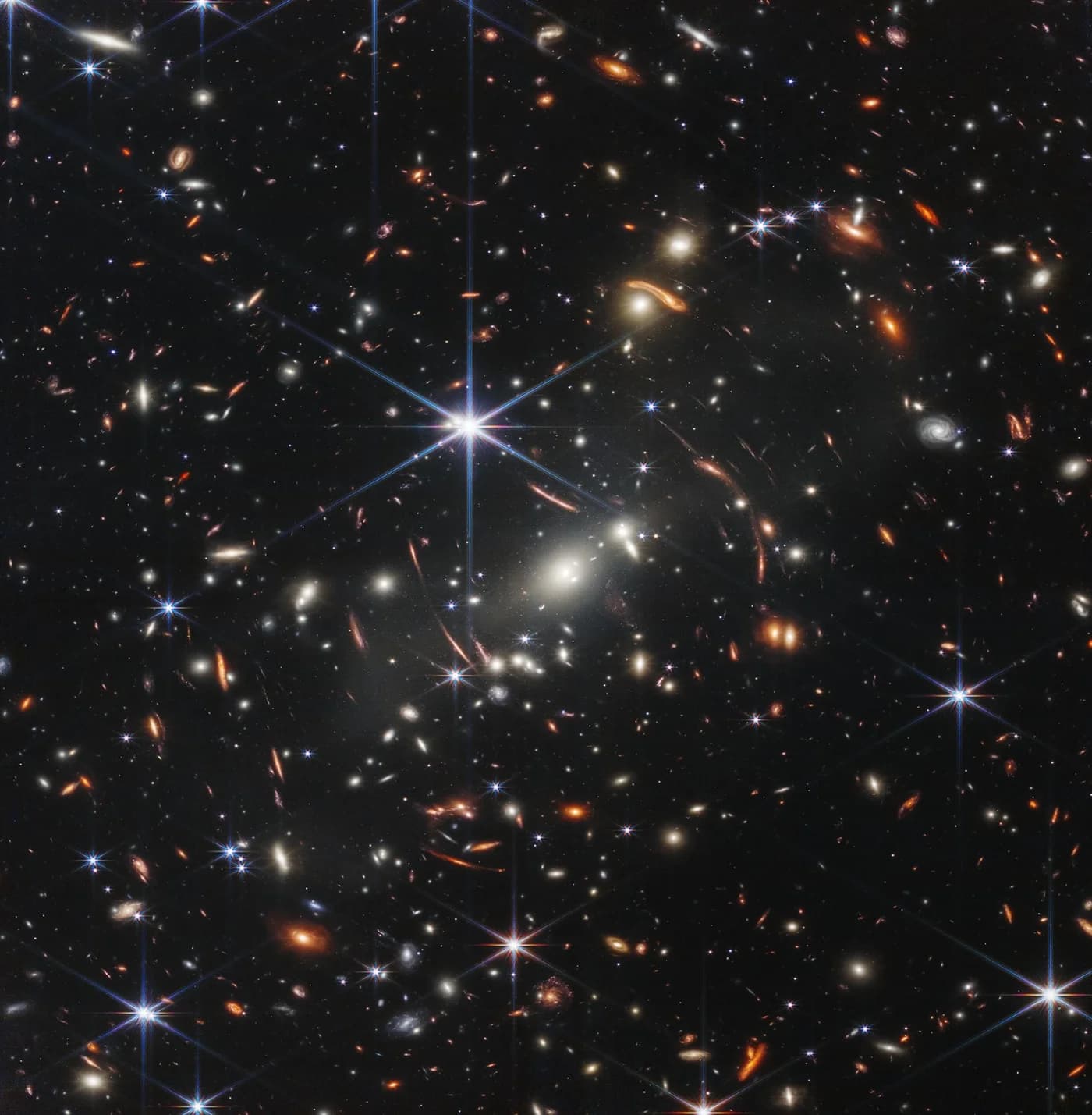 Webb's First Deep Field: a near-infrared NIRCam image of the galaxy cluster SMACS 0723, whose gravity bends and magnifies the light of more distant galaxies behind it. Released in July 2022.