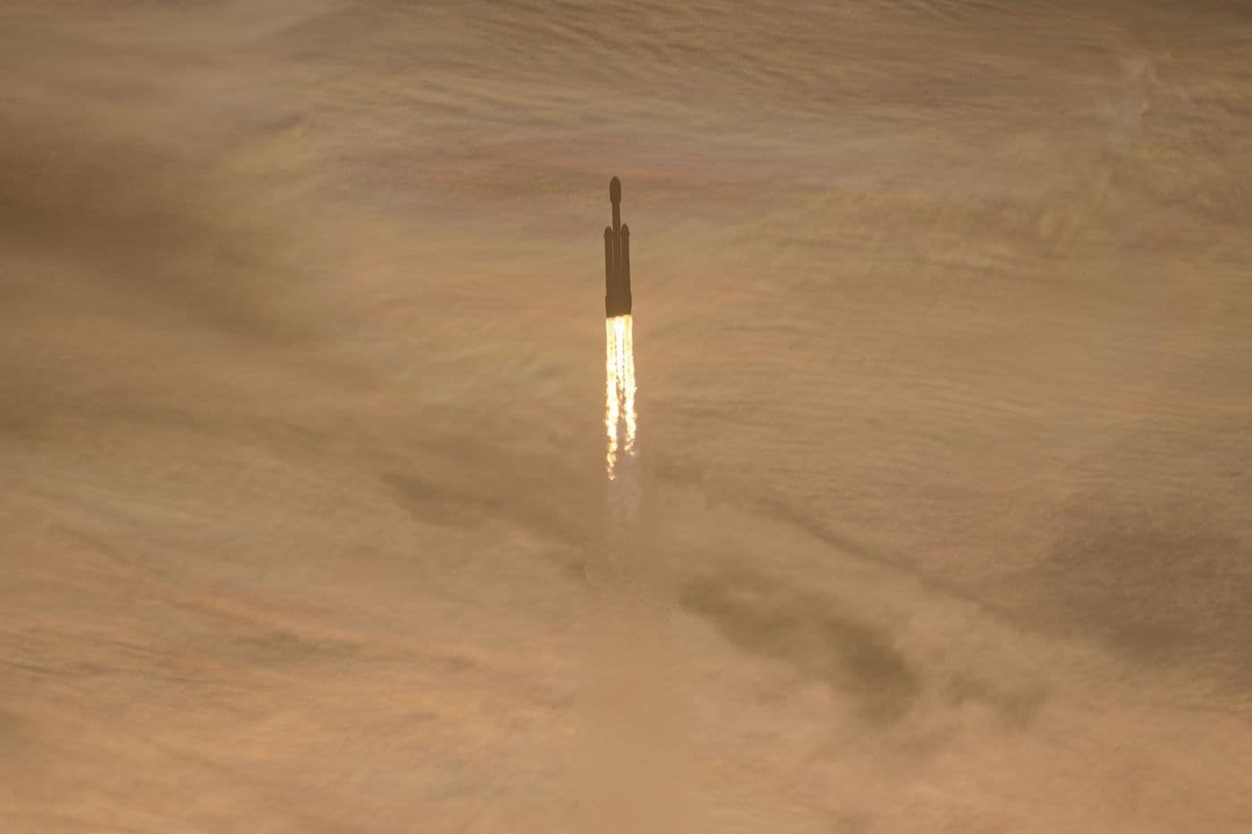 Raketa Falcon Heavy s teleskopem Nancy Grace Roman stoupá po startu nad Kennedyho kosmickým střediskem v oblacích zbarvených ranním světlem.