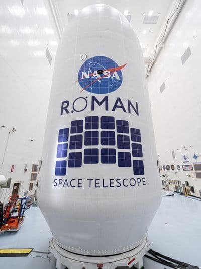 Technici v čisté hale připravují teleskop Nancy Grace Roman k uzavření do aerodynamického krytu před startem.