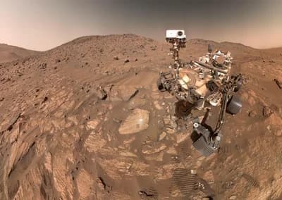 Selfie from 23 July 2024 (sol 1,218) with the arrowhead-shaped rock "Cheyava Falls" to the left of the rover.