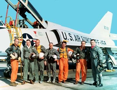 Skupinový portrét sedmi astronautů programu Mercury ve stříbrných skafandrech.
