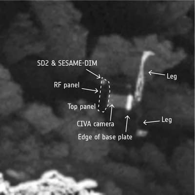 Philae zaklíněný v temné štěrbině, rozpoznaný na snímku úzkoúhlé kamery OSIRIS z 2. září 2016 ze vzdálenosti 2,7 km; popsáno je tělo modulu a dvě ze tří nohou.