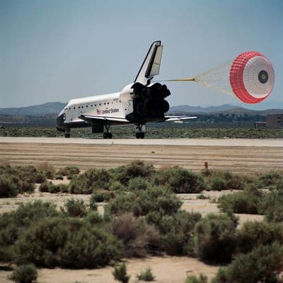 Raketoplán Endeavour dosedá na dráhu s vypuštěným brzdicím padákem.