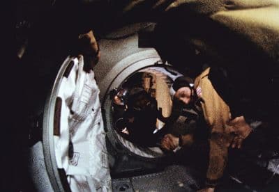 Podání ruky ve vesmíru — astronaut a kosmonaut se setkávají v průlezu mezi loděmi Apollo a Sojuz.