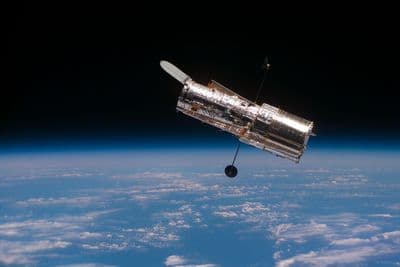 Hubbleův kosmický dalekohled na oběžné dráze nad Zemí, vypuštěný a servisovaný raketoplánem.