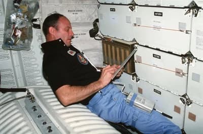 Jack Lousma records plant-growth experiment data aboard Columbia.