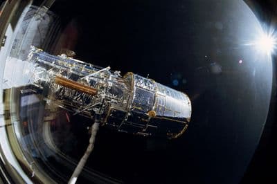 Hubbleův dalekohled je vyzdvihován z nákladového prostoru Discovery při misi STS-31.