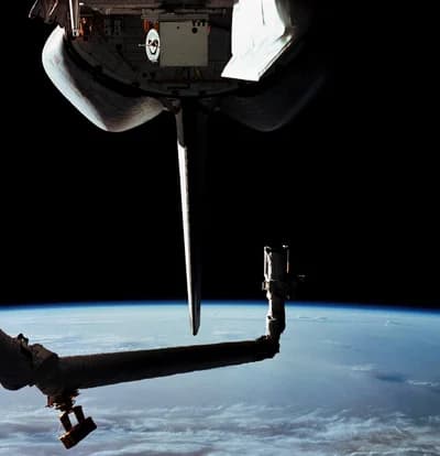 The Canadarm and part of the OSTA-1 payload above Earth during STS-2.